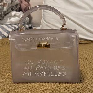 Stylish Transparent Un Voyage Handbag with Gold Accents